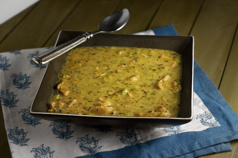 Broccoli Cheddar Soup Roasted broccolini, potato and smoked gouda soup in a square bowl